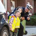 A police officer practices safe behavior in road traffic with children