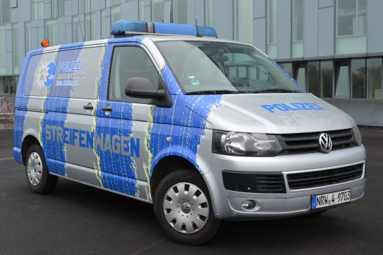 Ein VW Bus der Polizei ist mit einem auffälligen Streifenmuster versehen und dient als Info-Mobil.